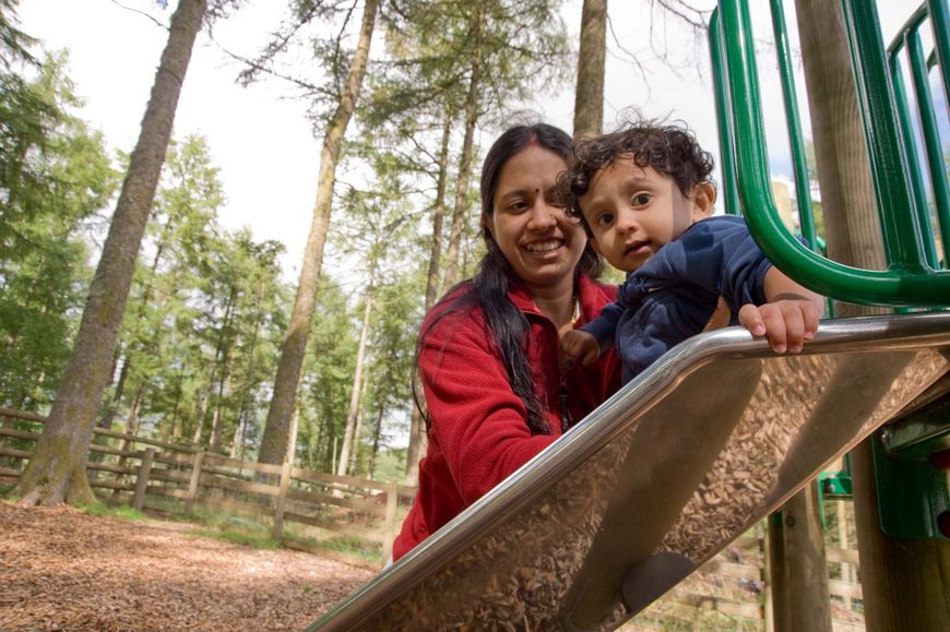 woman and toddler on slide in woodland park