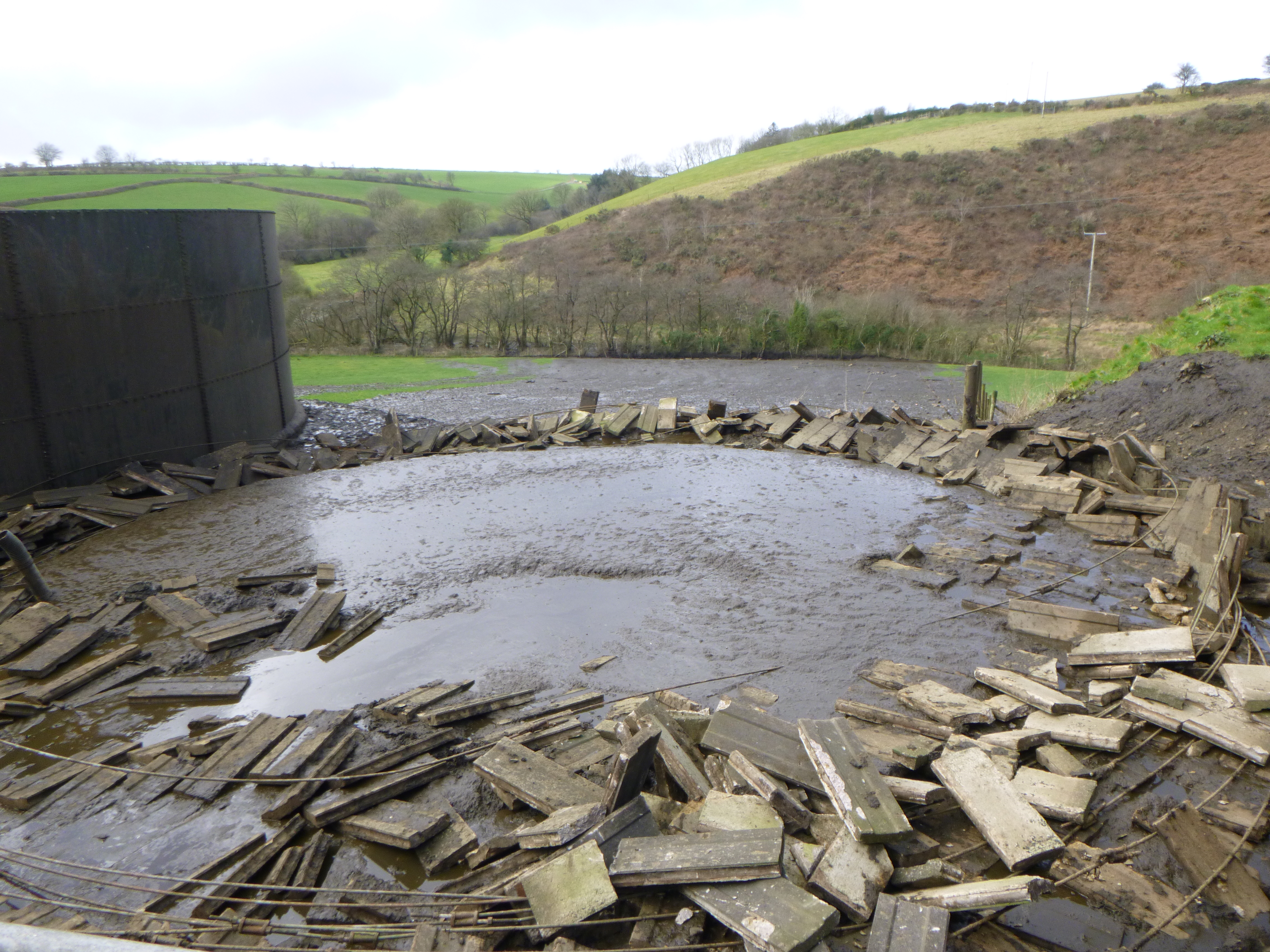 Collapsed slurry store with slurry running into the stream